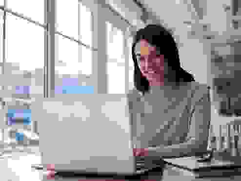 women smiling looking at a laptop